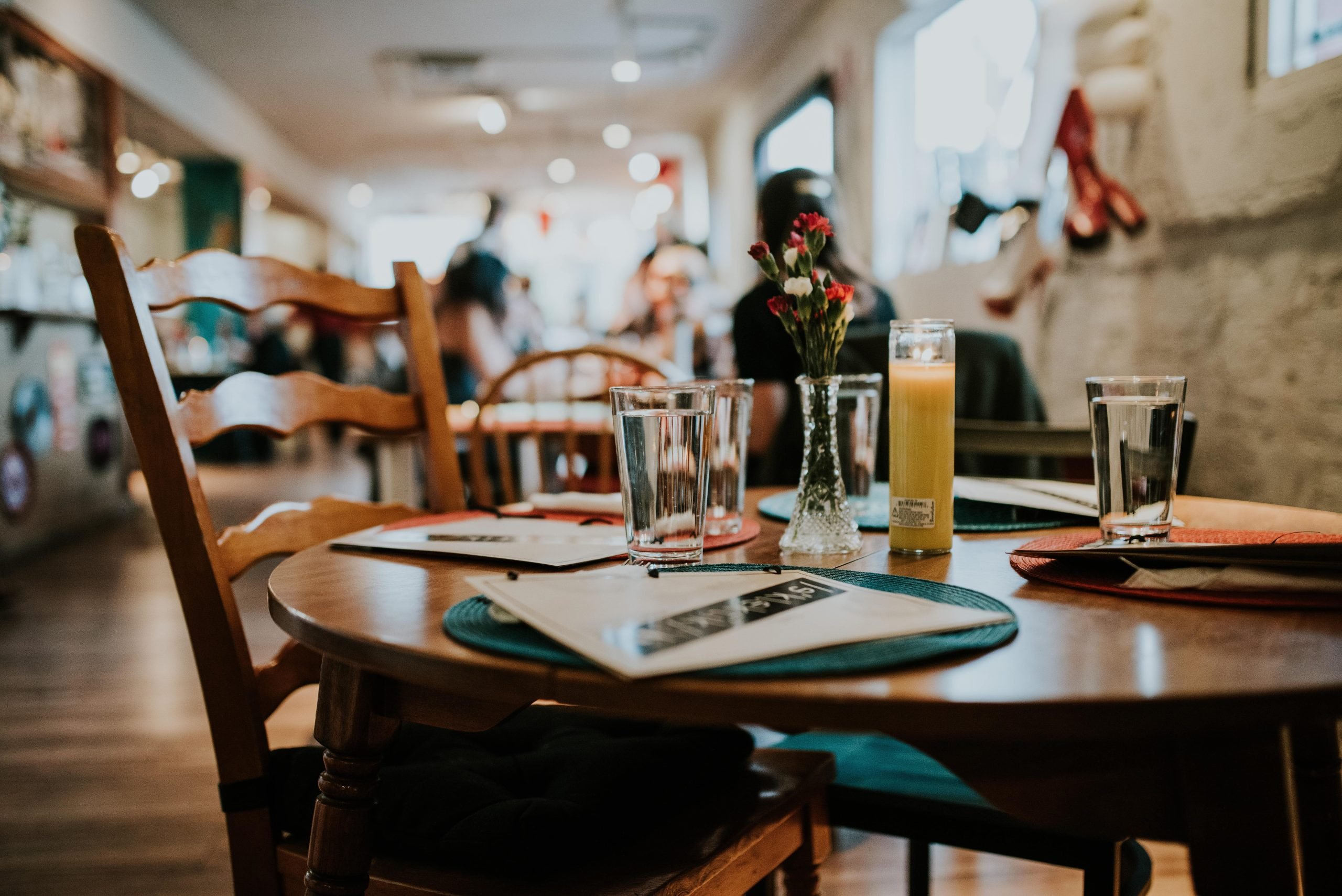 Imagen de un restaurante acogedor con mesas y sillas de madera, un jarrón de flores en la mesa y un ambiente cálido y agradable